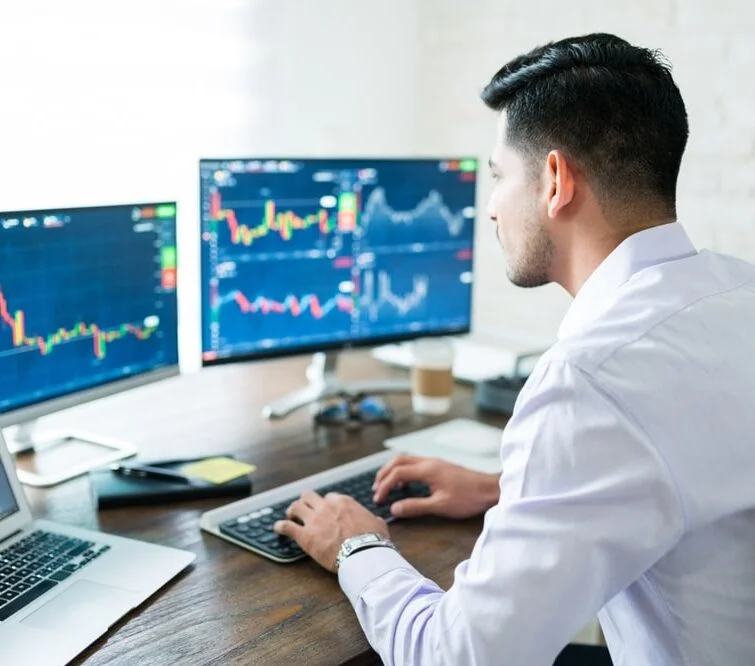 Man reviewing multiple financial charts on screen